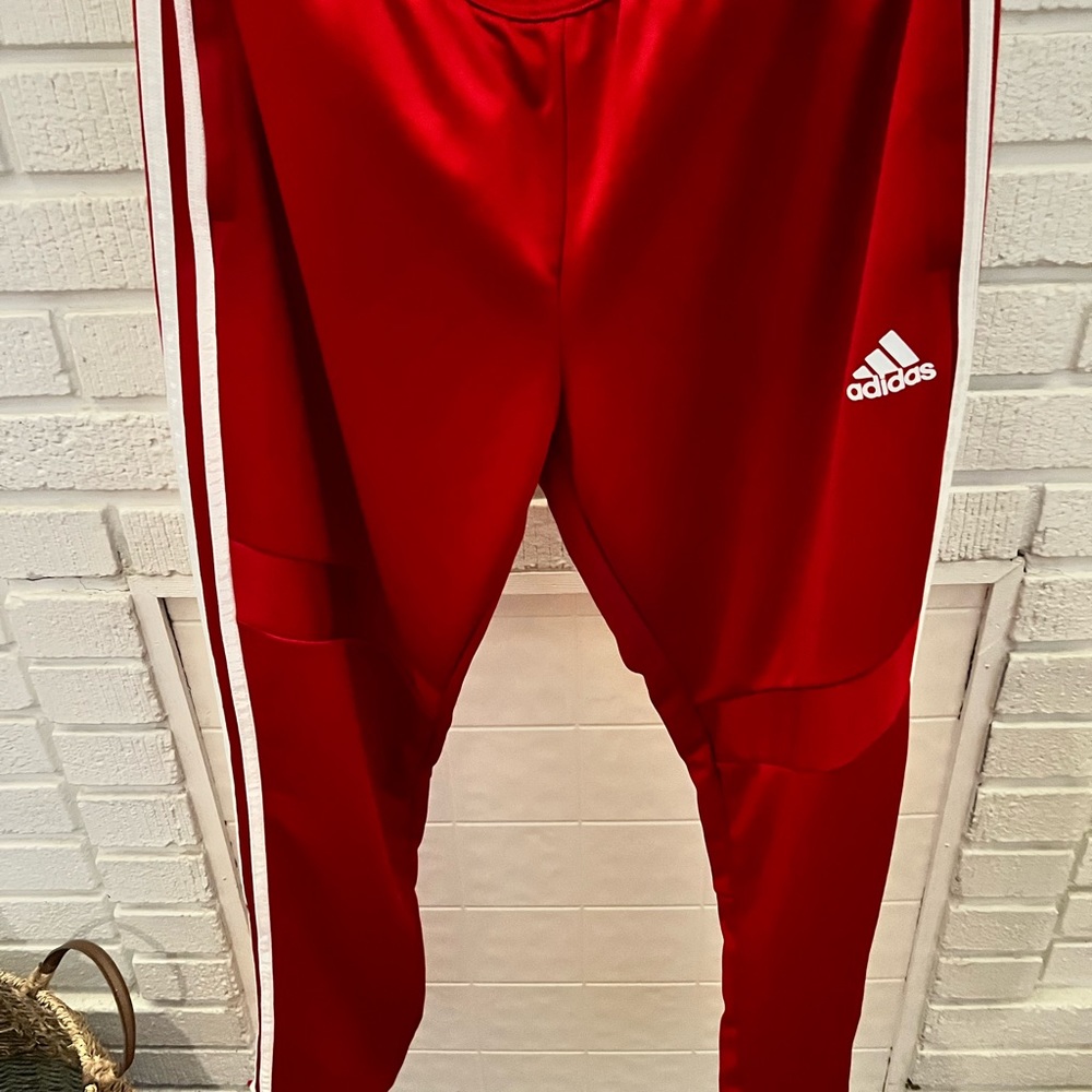Woman’s Adidas red with white stripes pants size L